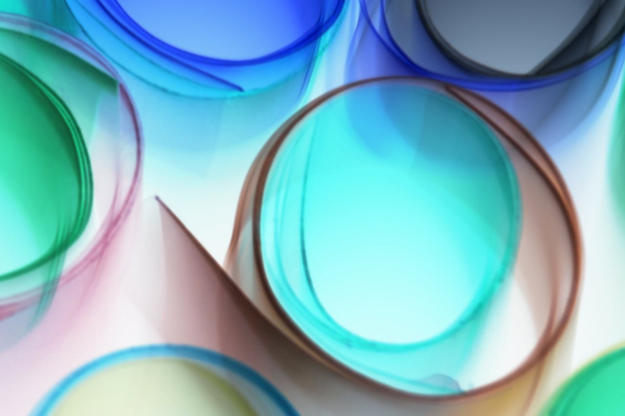 A vivid abstract design featuring rolled glass sheets in turquoise and other colors.