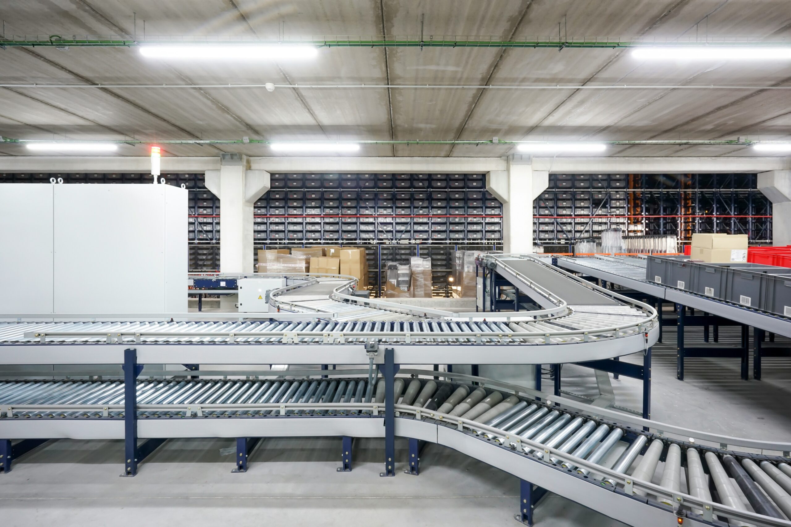 Automated warehouse conveyor with cardboard packages for hot-melt PSA packaging tape recyclability discussion